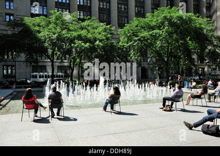 Les gens se détendre à la fontaine dans le Chicago's Daley Plaza. Banque D'Images