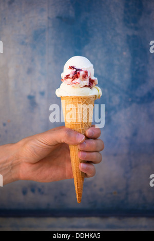Man holding cherry ice cream wafer cone dans Banque D'Images