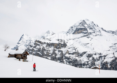 Old log cabin et skieur, Oberland bernois avec Mt Eiger en hiver, Alp Gimmeln Banque D'Images