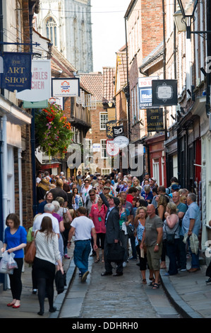 Consommateurs et aux touristes de marcher dans le quartier médiéval de Shambles au centre ville de York North Yorkshire England UK Banque D'Images