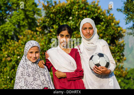 Trois filles du Cachemire, l'un tenant un ballon de soccer, deux portant le foulard Banque D'Images