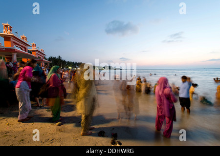 Pèlerins hindous en prenant un bain dans la mer sainte avant le lever du soleil, à l'Agni Theertham Ghat Banque D'Images
