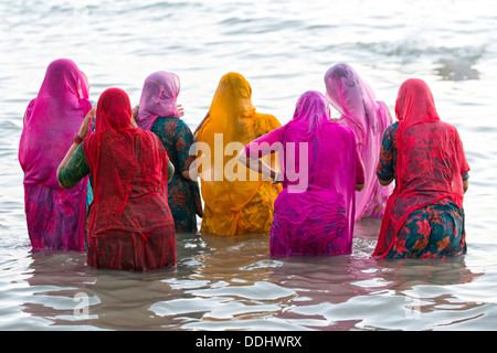 Pèlerins hindous, les femmes en saris colorés en prenant un bain sacré om la mer avant le lever du soleil, à l'Agni Theertham Ghat Banque D'Images