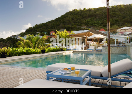 Bains de soleil sur terrasse en bois d'une piscine extérieure Banque D'Images