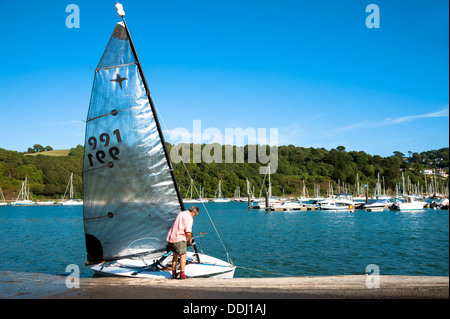 L'homme d'obtenir un voile canot prêt pour une excursion sur la rivière à Dartmouth, Devon, UK. Banque D'Images