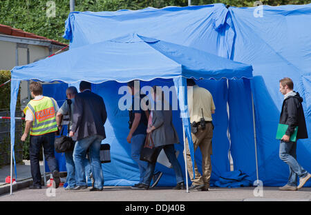 Berlin, Allemagne. 06Th Sep 2013. Les officiers judiciaires de marche en avant d'une scène de crime dans un quartier résidentiel de Berlin, Allemagne, 03 septembre 2013. Un homme a été abattu dans la rue. La scène du crime est protégé par des murs bleus. Les résidents a entendu des coups de feu tôt le matin et a appelé la police qui a trouvé un cadavre gisant sur le trottoir. Photo : PETER KNEFFEL/dpa/Alamy Live News Banque D'Images