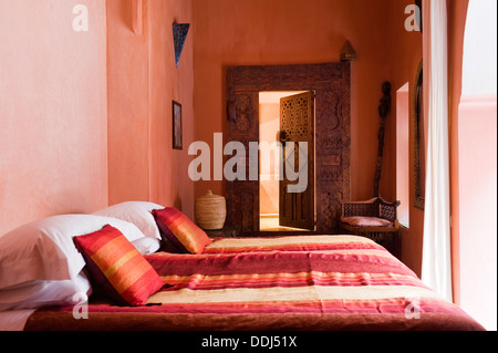 Chambre avec lit à rayures et de murs peints pastel de Riad à Marrakech Medina Banque D'Images