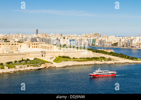 Bateau touristique à travers le port de Marsamxett et l'île Manoel, Malte. Banque D'Images