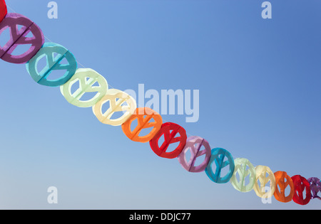 Guirlande papier coloré de signes de paix contre le ciel bleu. Banque D'Images