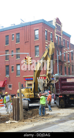 Mettre les travailleurs dans les nouveaux tuyaux sous la rue sur la 7e Avenue à Park Slope, Brooklyn, New York. Banque D'Images