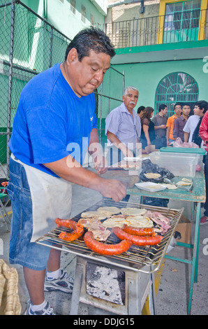 Barbecues pour l'homme du Mexique (long saucisses chorizo longaniza) et la viande à Food Festival à Puebla, Mexique. Banque D'Images