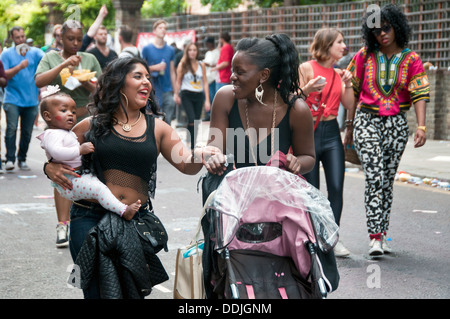 Les jeunes mères discutent dans la rue en milieu urbain avec des poussettes et bébés Banque D'Images