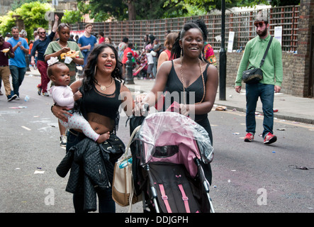 Les jeunes mères discutent dans la rue en milieu urbain avec des poussettes et bébés Banque D'Images