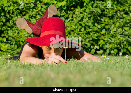 Jeune femme, chic, le choix d'un seul, tandis que daisy portant sur l'herbe sur une belle après-midi d'été Banque D'Images