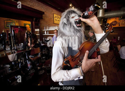 Detroit, Michigan, USA. 3e août, 2013. Le Violon, un monstre Ann Arbor, Michigan, violoniste de rue, de prendre son automne à Ale une bière à la release party de Arbor Brewing Company dans le centre-ville d'Ann Arbor, MI, le 3 septembre 2013. Le monstre a collaboré avec Arbor Brewing Company propriétaire Matt Greff pour créer une forte, épicé de saison ale. Après des recherches sur l'histoire de loup-garou, y compris les ingrédients brassage houblon allemand et minuit du blé ont été choisis en fonction des thèmes de la dualité, de la transformation, de la lumière et obscurité, et bien contre le mal. ''Nous avons ajouté beaucoup de houblon pour lui donner une morsure,'' dit Greff. (Crédit Image : Banque D'Images