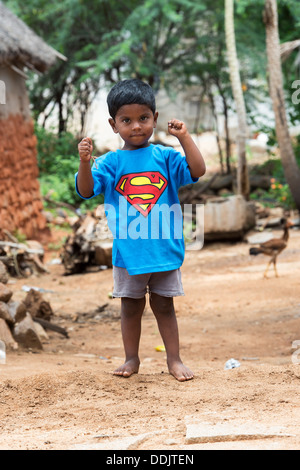 Jeune garçon indien vêtu d'un t shirt superman dans un village de l'Inde rurale. L'Andhra Pradesh, Inde Banque D'Images