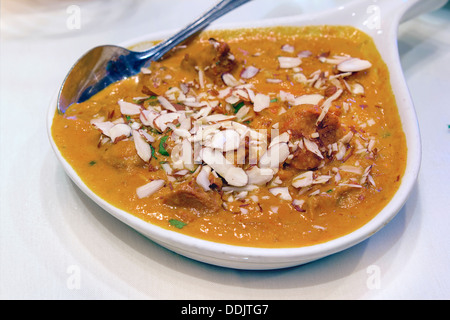 À l'Est de la cuisine indienne Korma Curry d'agneau avec des amandes tranchées closeup Banque D'Images