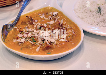 À l'Est de la cuisine indienne Korma Curry d'agneau avec des amandes tranchées et de riz Basmati closeup Banque D'Images