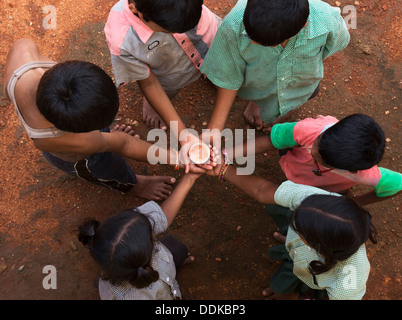 Les mains de childrens village situé dans un cercle tenant un globe en verre cristal / masse / monde. L'Andhra Pradesh, Inde Banque D'Images