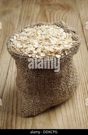 Flocon d'avoine dans un sac sur une table en bois Banque D'Images