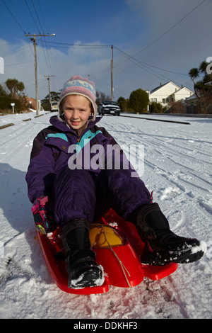 Jeune fille sur la neige en traîneau, Dunedin, Otago, île du Sud, Nouvelle-Zélande Banque D'Images