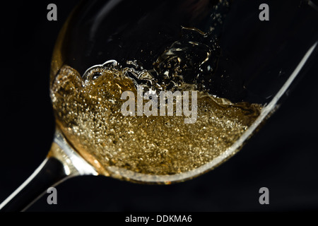 Le vin blanc est versé dans un verre. Banque D'Images