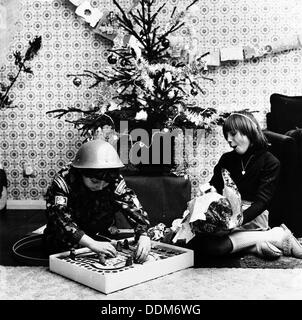 L'ouverture des cadeaux de Noël des enfants dans leur maison de Londres, c1960s. Artiste : Henry Grant Banque D'Images