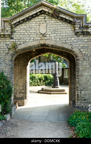 Une pompe dans un quartier résidentiel square vu à travers un passage voûté en brique à la 'Royal mariniers's hospices de Penge, le sud de Londres. Banque D'Images