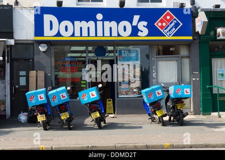 Une ligne de livraison scooters, tous avec l'assiettes, établi à l'extérieur de Domino's Pizzas de Penge, le sud de Londres. Banque D'Images