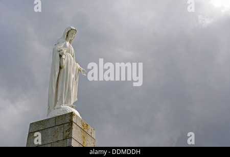 Statue en pierre de la Vierge Marie posée sur une pointe au-dessus d'Arromanches en Normandie, France. Banque D'Images