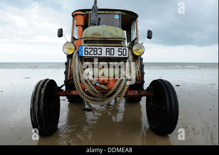 Plage de l'ancien français le tracteur utilisé pour lancer et récupérer des bateaux de pêche Banque D'Images