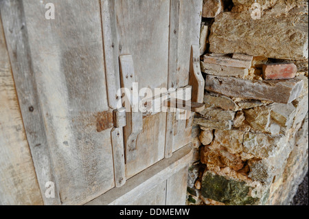 Ancienne grange en bois le loquet de porte intérieur et mur de pierre. Banque D'Images