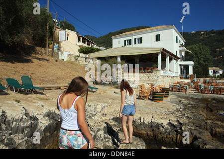 Les jeunes filles sur les rochers à Kalami Corfou en Grèce avec la Maison Blanche où les auteurs Gerald Durrell Lawrence et vécu Banque D'Images