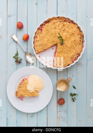 Crumble Tarte aux prunes avec une garniture sur un panneau bleu. Banque D'Images