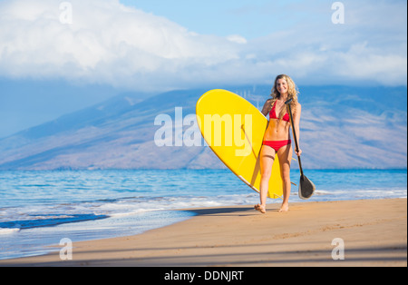 Jolie femme avec Stand Up Paddle Board, SUP, sur la plage à Hawaii Banque D'Images