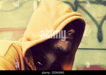 Portrait de jeune homme en Sweat capuche / cavalier sur le mur de graffiti grunge Banque D'Images