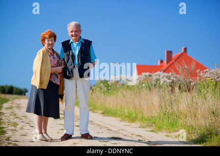 Happy senior couple devant leur maison Banque D'Images