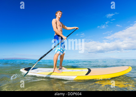 Homme séduisant sur le Stand Up Paddle Board, SUP, Hawaii, l'océan bleu tropical Banque D'Images