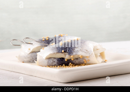 Hareng mariné avec des graines de moutarde sur une plaque Banque D'Images