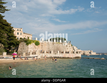 Nageurs à une petite plage sur Ortygie à Syracuse, Sicile, Italie Banque D'Images