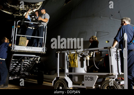 ALTUS AIR FORCE BASE, en Oklahoma - Les membres de la 97e Direction de l'entretien, les travaux de remplacement d'un générateur de lecteur intégré sur un U.S. Air Force C-17 Globemaster III pendant le quart de nuit sur l'aire, le 26 juin. Le 97e MX est l'un des nombreux escadrons t Banque D'Images