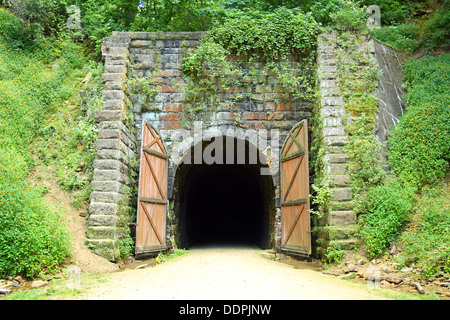 Une ancienne entrée du tunnel en pierre sur un sentier de randonnée à vélo dans les bois, qui a été converti à partir d'une ancienne voie de chemin de fer. Banque D'Images