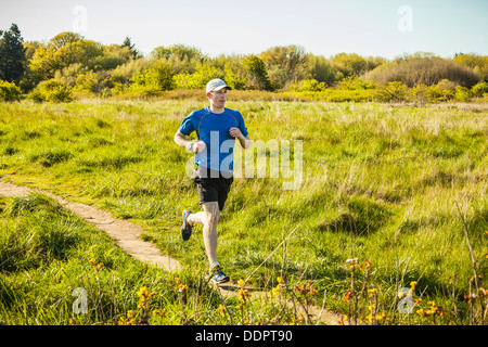 Un jeune homme le jogging dans le parc de découverte, Seattle, Washington. Banque D'Images