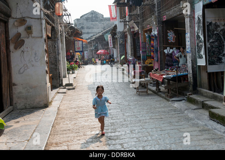 Petite fille qui marche sur une rue, Xingping, Yangshuo, Guilin, Guangxi Province, China Banque D'Images