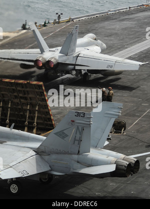 Un F/A-18E Super Hornet, haut, affecté à l'escadron de combat interarmées des Argonautes (VFA) 147 se prépare à lancer sur le pont d'envol du porte-avions USS Nimitz (CVN 68) qu'un F/A-18C Hornet affectés à l'diamants bleus de Strike Fighter Squadron ( Banque D'Images