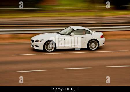 Synchro flash arrière technique utilisée pour capturer un white BMW Z4 sDRIVE35est voiture roulant le long de la quatre voies à Dundee, Royaume-Uni Banque D'Images