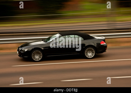 Synchro flash arrière technique utilisée pour capturer une BMW Série 6 Cabriolet voiture roulant le long de la quatre voies à Dundee, Royaume-Uni Banque D'Images