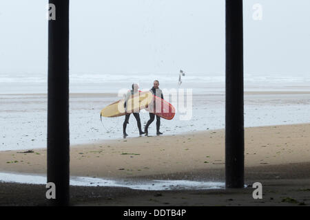 Les surfeurs sur la plage de Nice en cas de pluie. Marseille par la mer, North Yorkshire, England, UK Banque D'Images