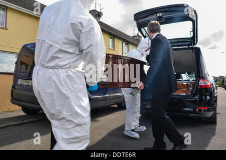 Bailieborough, comté de Cavan, République d'Irlande, 6 septembre 2013 - Deux agents d'investigation et de pompes funèbres charger un cercueil dans le corbillard d'attente à l'extérieur de la maison de 54 ans, Patricia Kierans où son corps a été découvert à l'attente corbillard. Elle a été "violemment assassiné' Crédit : Stephen Barnes/Alamy Live News Banque D'Images