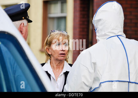 Bailieborough, comté de Cavan, République d'Irlande, 6 septembre 2013 - L'État anatomopathologiste Dr Marie Cassidy parle aux agents de garde à l'extérieur de la maison de 54 ans, Patricia Kierans où son corps a été découvert à l'attente corbillard. Elle a été "violemment assassiné' Crédit : Stephen Barnes/Alamy Live News Banque D'Images